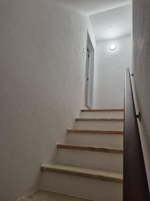 Escadas de mármore com corrimão de madeira escura