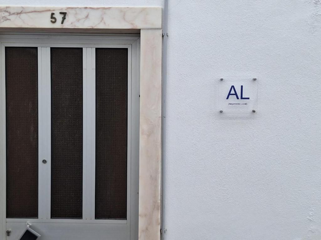 Porta da Casa Branco, com o número 57 em moldura de mármore e a placa de Alojamento Local
